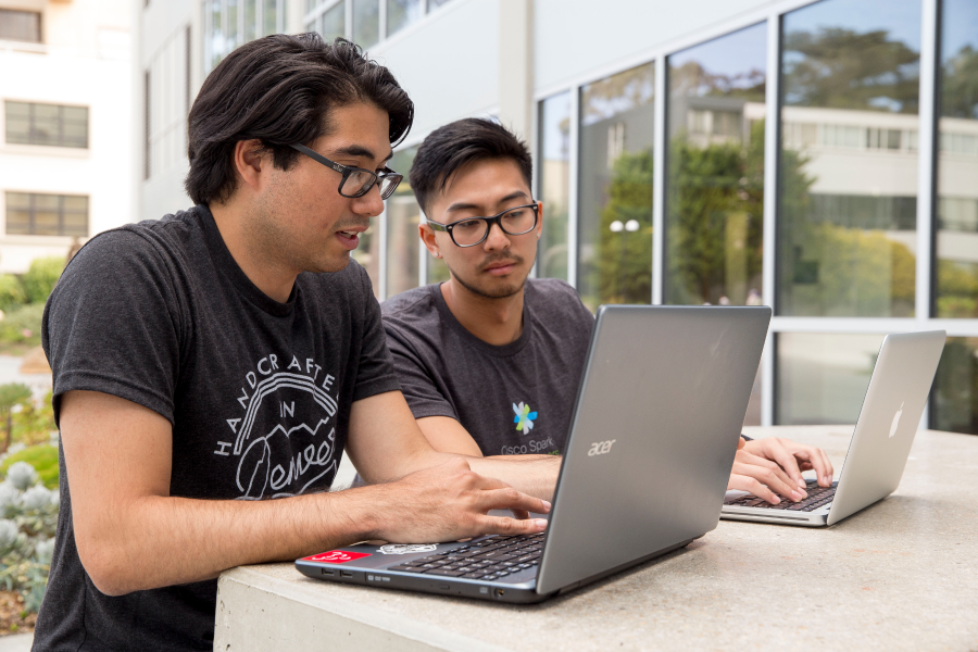 Two students working on laptops.